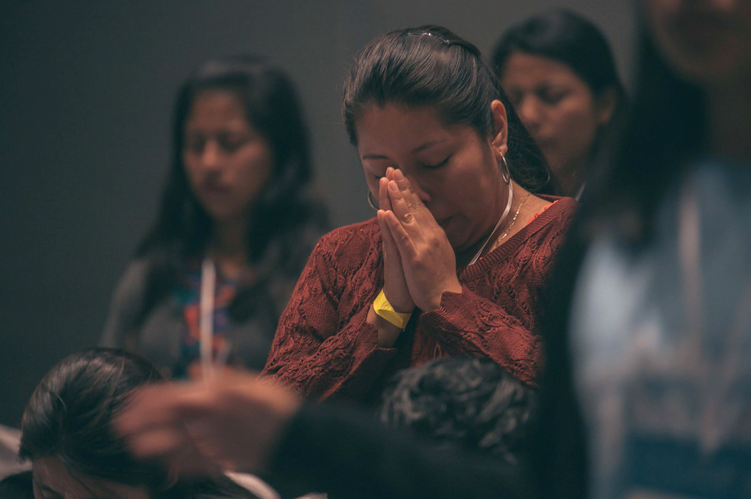 A Guatemalan women closes her eyes and prays at a religious service